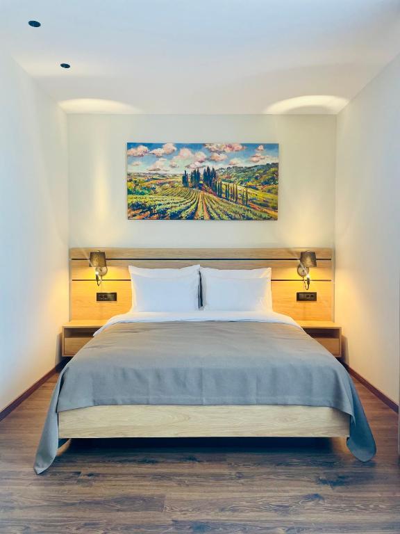 Krevet u apartmanu ispod slike fruškogorskih vinograda